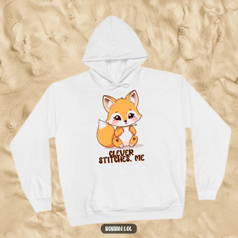 Funny fox with a determined look threading a needle, depicted on a warm and humorous hoodie.