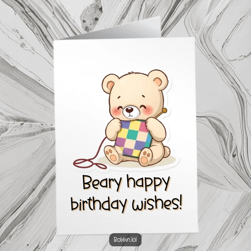 Funny Free Printable Birthday Card: A tiny bear happily stitches a colorful quilt square with a needle for a birthday.